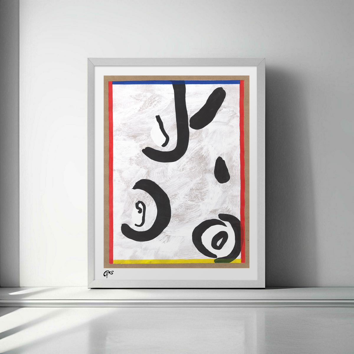Framed abstract artwork with black, red, yellow, and blue on a white wall.